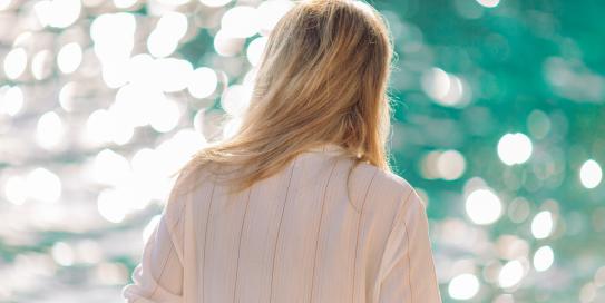 Blonde Frau schaut auf das Meer