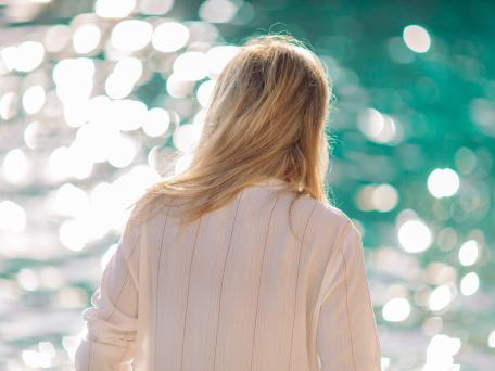 Blonde Frau schaut auf das Meer