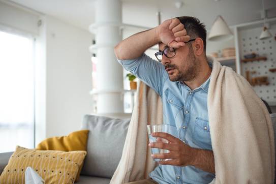 erschöpfter Mann mit Decke über den Schultern