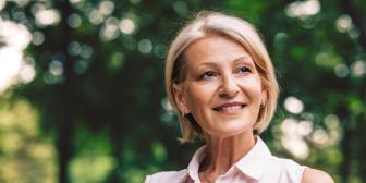 lächelnde Frau mit Wald im Hintergrund